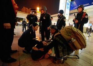 Miembros de las fuerzas de seguridad chinas prestan auxilio a una mujer herida en la estación de Kunming./ MARK RALSTON/ AFP