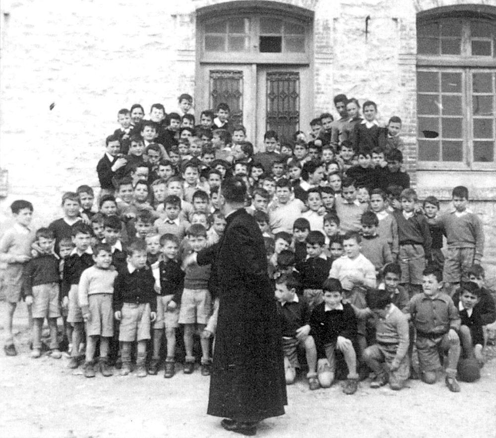 Don Conrado con los alumnos internos del Hogar Infantil de Suances, en los años 40