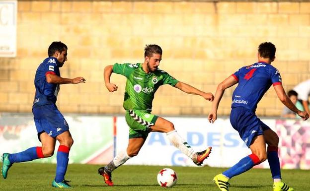 Heber conduce el balón ante dos jugadores del Amorebieta. 