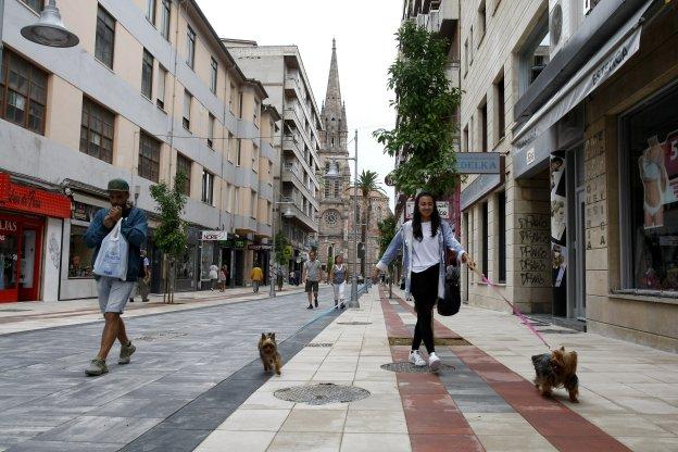 Varios peatones caminan por el tramo recién remodelado de la calle Consolación, una de las principales arterias comerciales de Torrelavega. 