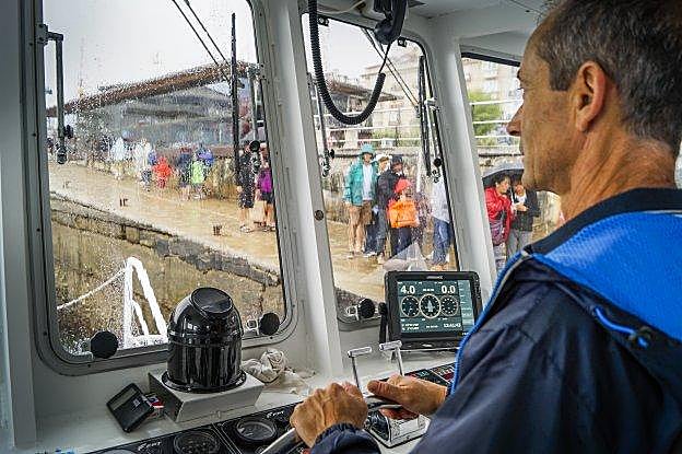 El patrón de la embarcación aguarda el embarque de los pasajeros para zarpar con rumbo a Somo