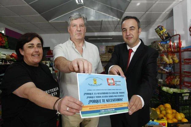 Marta Saiz, Amable Fernández y Ángel Sainz muestran el cartel de la campaña de seguridad en el barrio