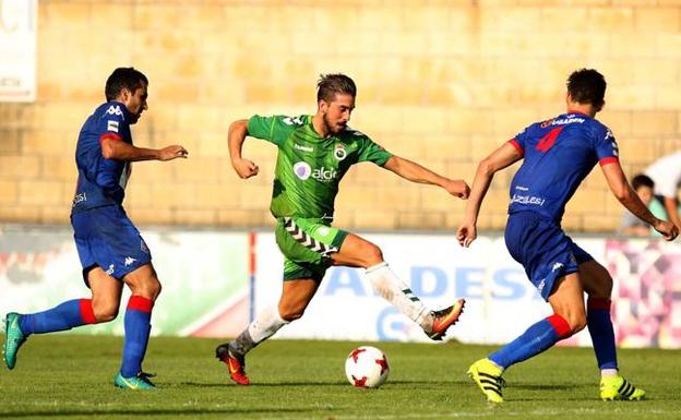 Héber trata de zafarse de dos futbolistas del Amorebieta en el partido de pretemporada disputado este verano. 