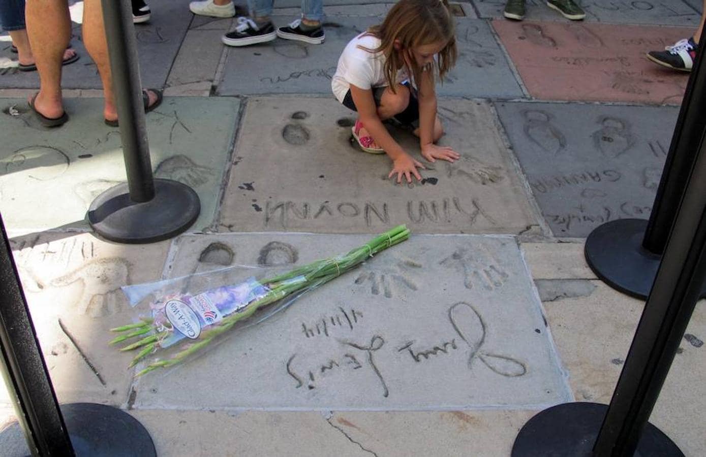 Una niña deja sus huellas de mano junto a las de Jerry Lewis.