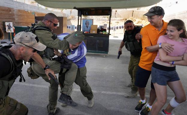 Los instructores, antiguos miembros de unidades especiales del Ejército hebreo, repelen un simulacro de agresión con cuchillo junto a dos de sus clientes.