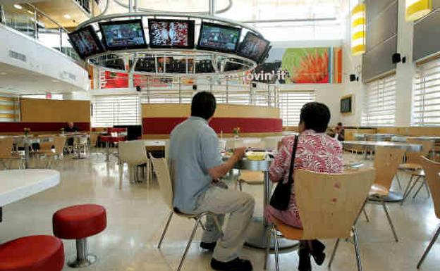 Dos clientes sentados en un restaurante de McDonald's.