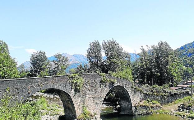 Encanto rústico. El puente medieval de Ponte d’Arcu, en el concejo de Laviana, con la serranía recortándose contra el cielo.