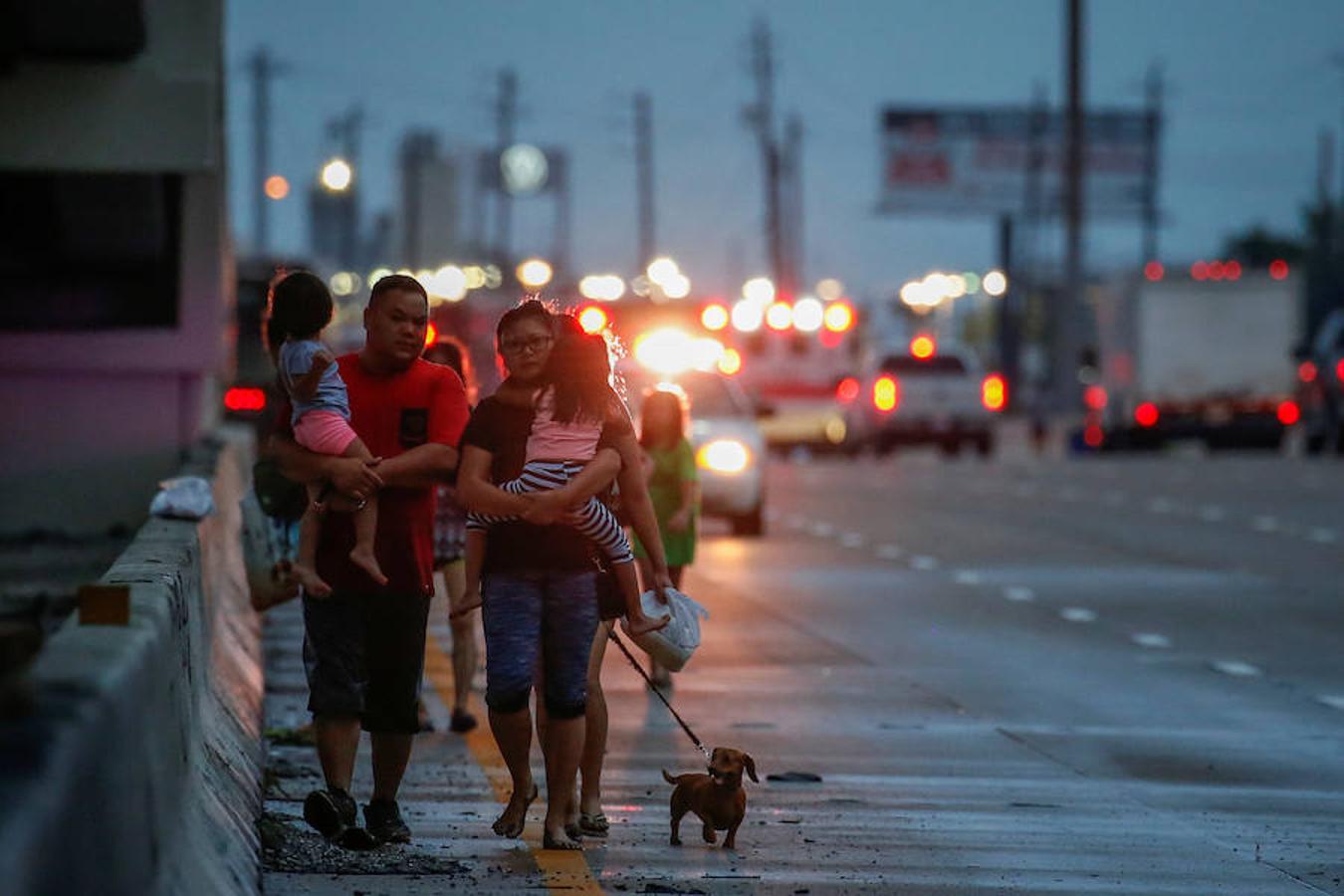 La familia Duong, con niños, padres y perro camina por la carretera mientras se escapa de Harvey.