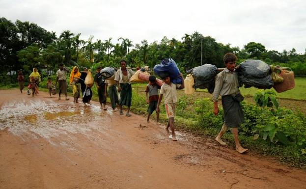 Varios refugiados caminan hacia la frontera.