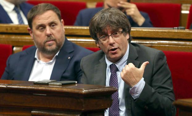 Puigdemont (d) junto al vicepresidente del Govern, Oriol Junqueras (i), durante el debate. 