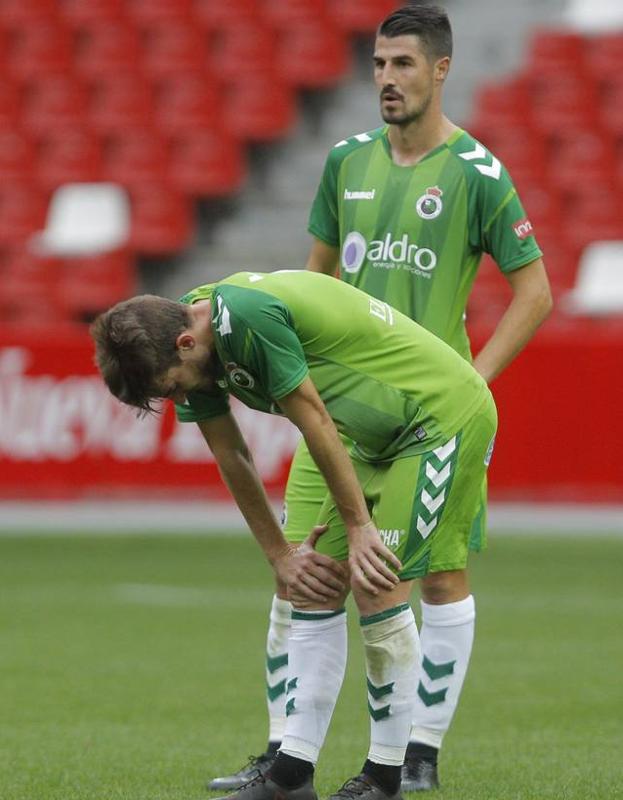 Quique Rivero (agachado) y Álex García, cariacontecidos tras la derrota de El Molinón. 