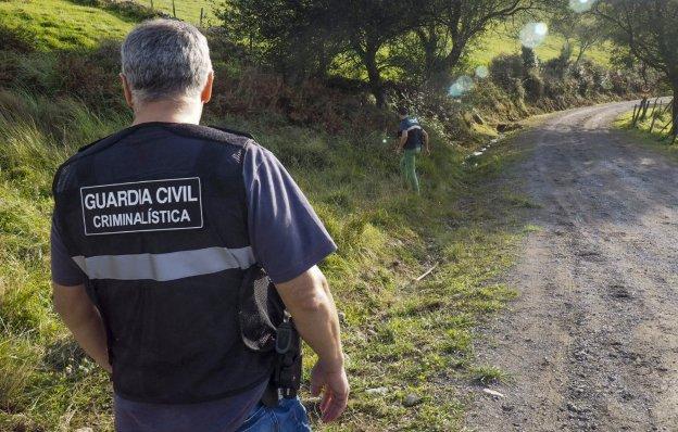 Dos agentes de la brigada de Criminalística inspeccionan el lugar donde fue hallado el cuerpo sin vida de Esther Díaz.