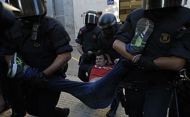 Los Mossos desalojan a un manifestante.