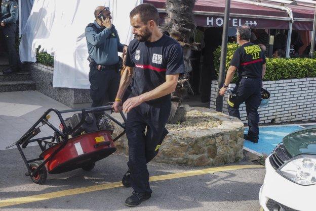 Un bombero transporta al interior del hotel un ventilador para extraer los gases acumulados