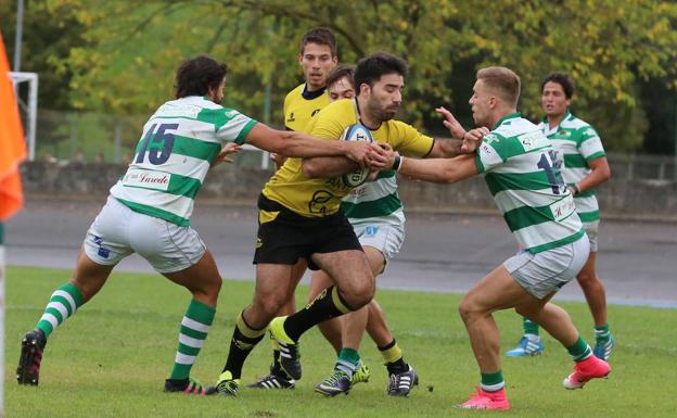 'Viti', Nacho Poet y Lucas Latrónico intentan detener a un jugador del Getxo.