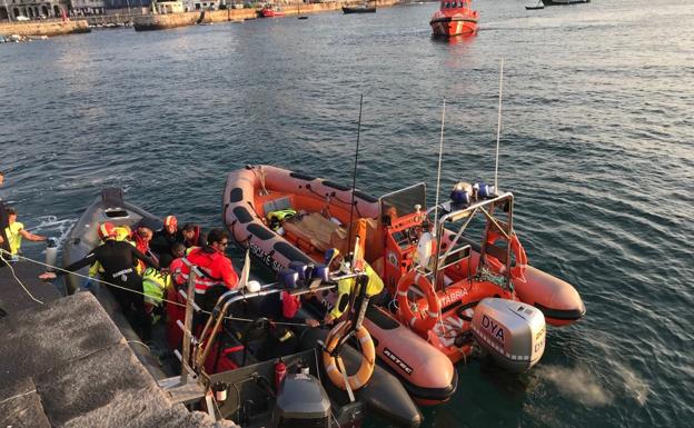 El helicóptero del 112 localizó al pescador y fue recogido por la embarcación de los bomberos (en la imagen), donde le intentaron reanimar. 