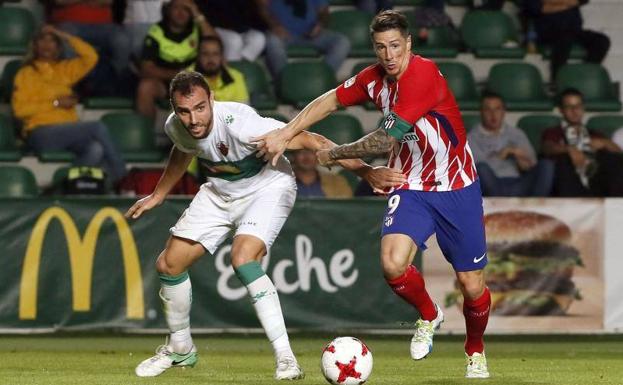 Fernando Torres porfía por un balón con un defensa del Elche. 