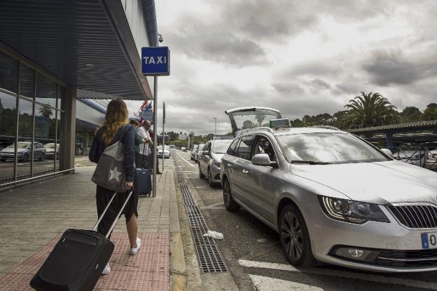 Varios viajeros, en la parada de taxis del aeropuerto Seve Ballesteros. 