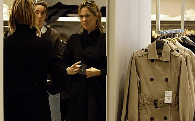 Una mujer se prueba un abrigo.