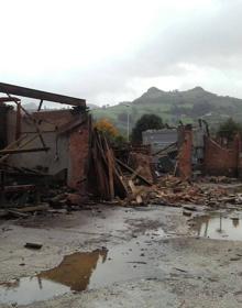 Imagen secundaria 2 - Imágenes de la serrería desplomada y de los bomberos achicando el agua del túnel de la estación de Los Corrales de Buelna.