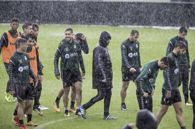 Los jugadores del Racing, ayer, durante el entrenamiento en La Albericia, en medio de una intensa lluvia.