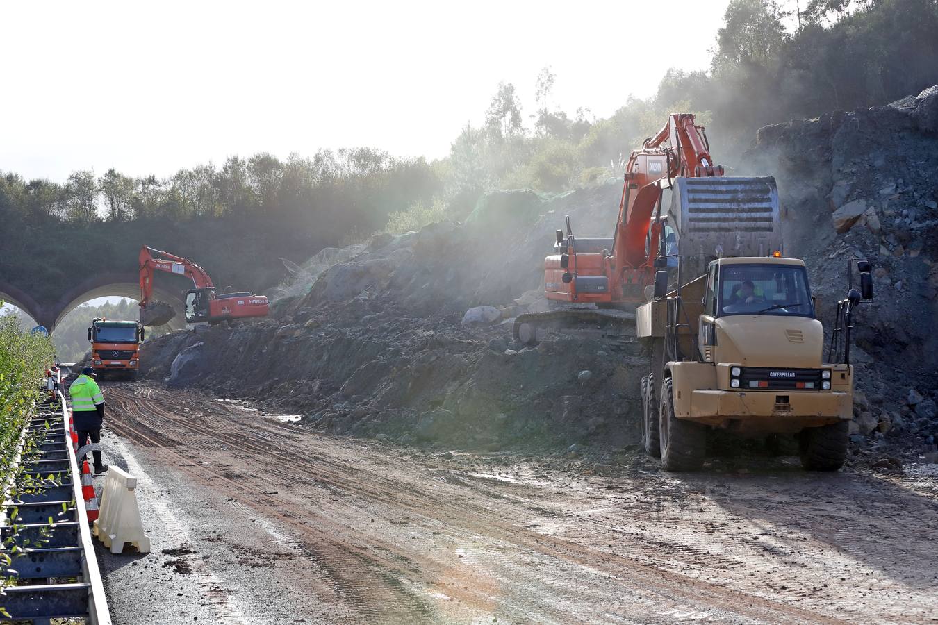 Las máquinas y el personal trabajan para despejar los dos carriles cortados por un argayo a la altura de Caviedes