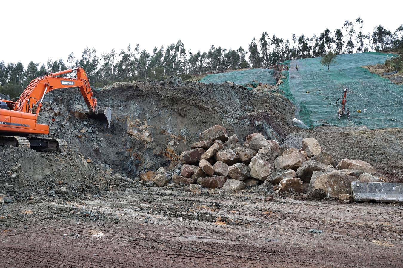 Las máquinas y el personal trabajan para despejar los dos carriles cortados por un argayo a la altura de Caviedes