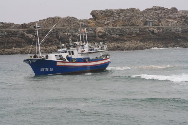 Un pesquero varado en la entrada del puerto de San Vicente por la roca que ahora se eliminará. 