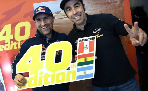 Stephane Peterhansel y Nani Roma, con el cartel del Dakar 2018. 