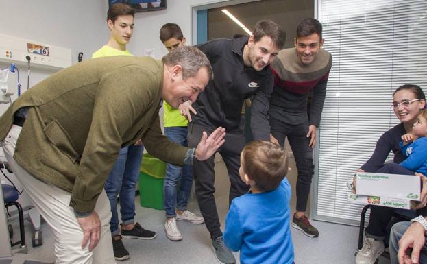 Viadero, Julen e Iván Crespo saludan a unos niños en la zona de Urgencias pediátricas del Hospital de Valdecilla.