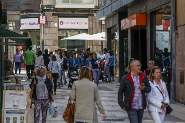 Vecinos de Torrelavega caminan por el centro de la ciudad. 