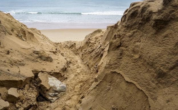 El oleaje rompe la duna y la erosión destapa rocas de la antigua costa, anterior a la formación de la playa.