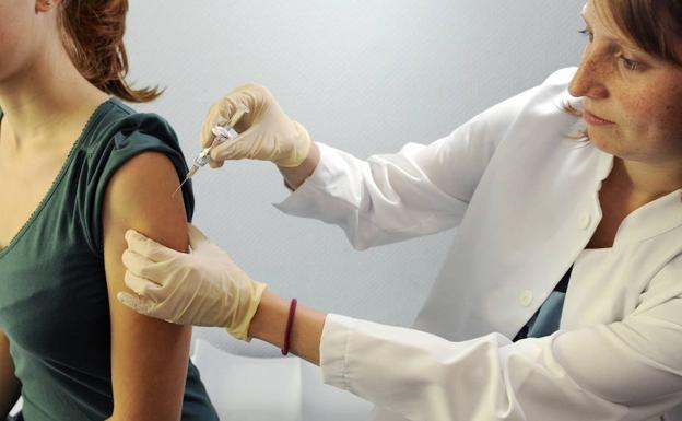 Una doctora enseña cómo llevar a cabo una vacunación contra la gripe. 