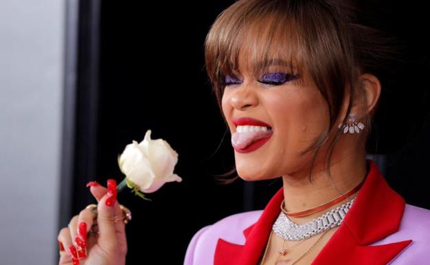 Andra Day sostiene una rosa blanca.