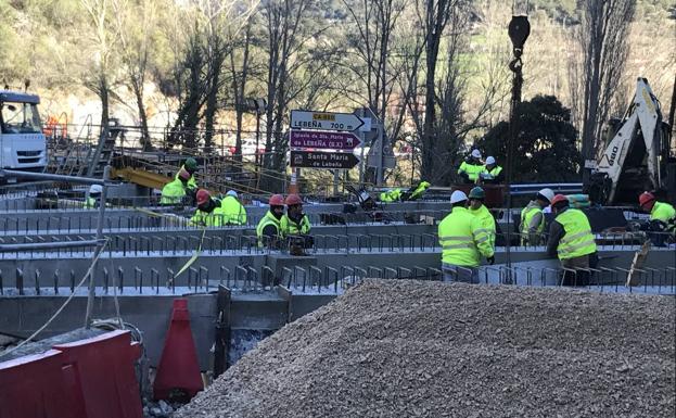 Los obreros trabajan en la nueva pasarela de Lebeña.