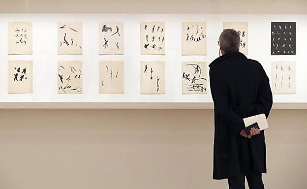 Un hombre observa diferentes dibujos que forman parte de la nueva exposición de Henri Michaux.