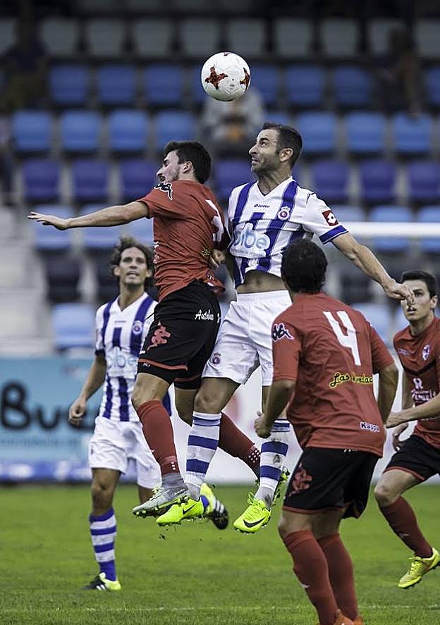 Víctor, de la Gimnástica, protege el balón ante un rival.