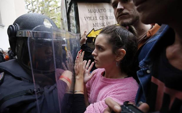 Un agente y varios ciudadanos durante la jornada del 1 de octubre. 