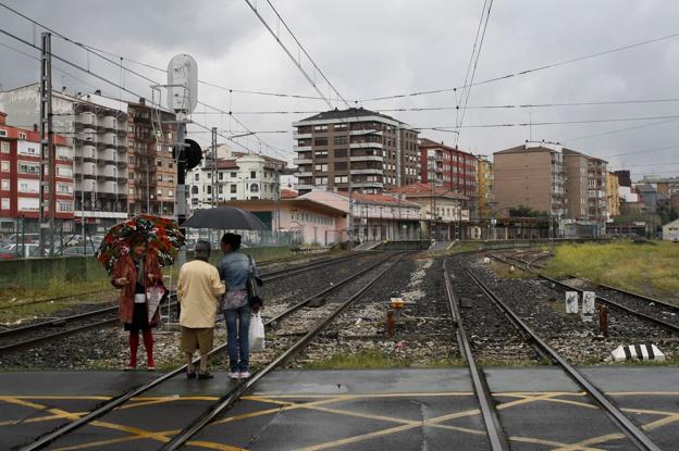 Tres mujeres caminan por el paso a nivel de las vías del tren en la calle Pablo Garnica, uno de los que parte a la ciudad en dos. 