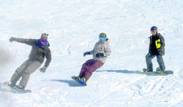 Tres amigos, que practican el snowboard desde hace varios años, se deslizan por la pendiente de la zona azul de Alto Campoo.