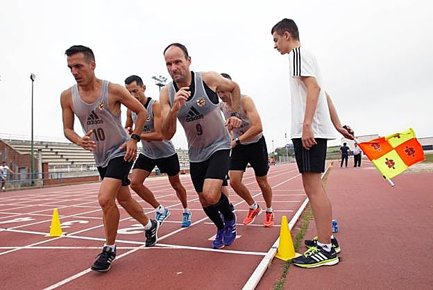 En forma. Estrada Fernández y Mateu Lahoz (delante), seguidos de Sánchez Martínez y Undiano Mallenco, durante unas pruebas físicas. Abajo, colegiados y asistentes en una reunión técnica. 