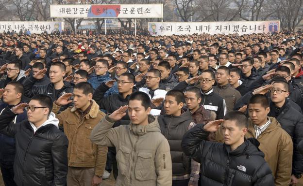Jóvenes reclutas hacen el saludo militar en la explanada de un centro de entrenamiento del Ejército surcoreano.