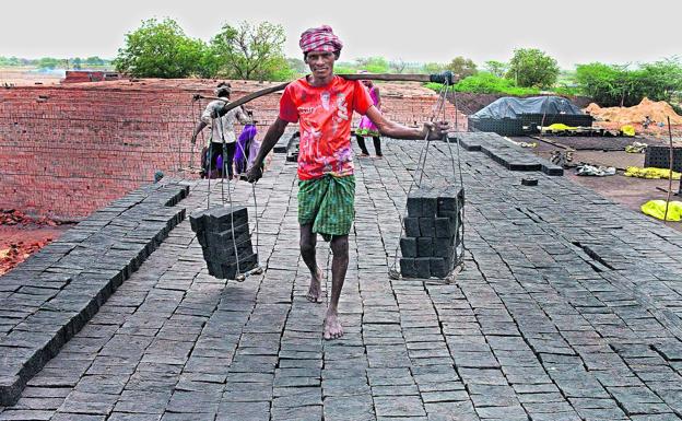 Un hombre traslada ladrillos en un horno de la India, el país donde más personas malviven en condiciones de servidumbre