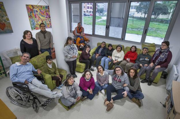 Los quince usuarios del centro, con sus terapeutas y cuidadores, en la sala de estar del centro que han estrenado esta misma semana. 