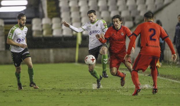 Adán Gurdiel y Héber disputan un balón a dos jugadores del Sanse durante el partido de ida en los Campos de Sport. 