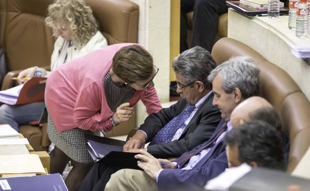 La consejera de Sanidad habla con el presidente durante el pleno.