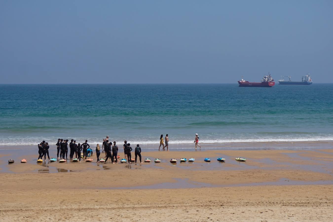 Enfundados en el neopreno a aprender a surfear en la primera del Sardinero.