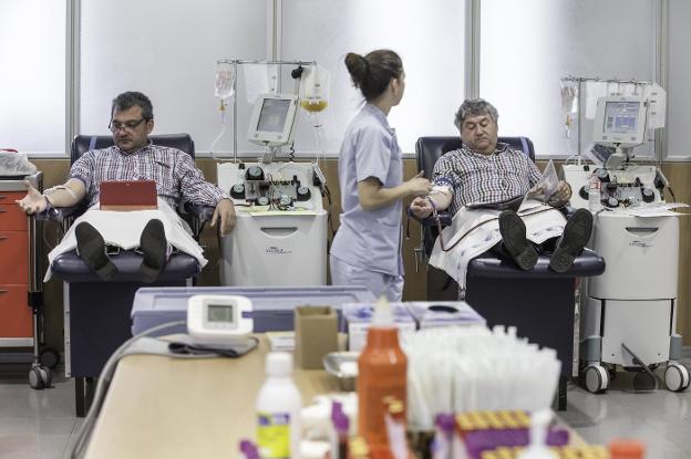 Amado González y Francisco García, dos donantes habituales de aféresis, en pleno proceso en la sala del Banco de Sangre, en el pabellón 13 de Valdecilla. 