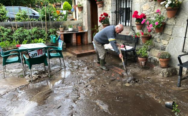 Un vecino de Pechón limpia su casa tras la inundación de esta mañana.