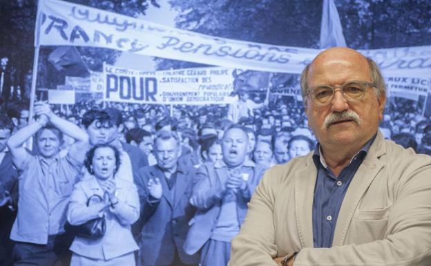 Carlos Nieto posa junto a una de las imágenes históricas de la revuelta.